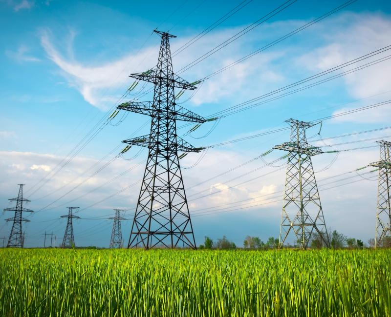 Electricity pylons on a green field